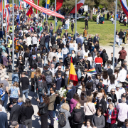 Menschenmenge bei der Internationalen Befreiungsfeier 2025 mit internationalen Fahnen